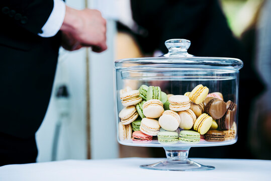 Macarons color&eacute;s avec plusieurs parfums dans un pot en verre sur un buffet de mariage
