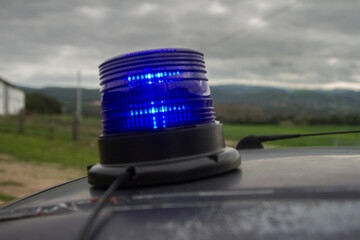 up view of close-up of a blue police flashing light on on the roof of the car