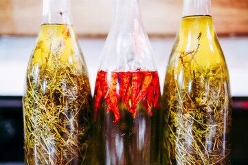 Trois bouteilles d'huile d'olive aromatisées aux herbes et piment