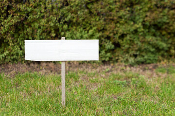 Blank mock up wooden sign in the garden. Concept for advertisement, guide board, tourism wood sign.