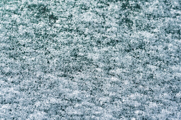 Fototapeta na wymiar Melting snow on the car window. Close-up of ice crystals.