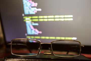 Wordpress theme code close up through sunglasses. Laptop screen with CSS code