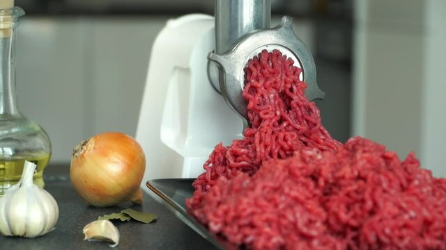Process of raw fresh meat beef grinding in kitchen with mincing machine. Meat cooking concept. Food background