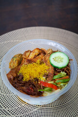 Nasi Ambeng or Nasi Ambang. It is a fragrant rice dish that consists of steamed white rice, chicken curry or chicken stewed in soy sauce, beef or chicken rendang, sambal goreng urap, bergedel.