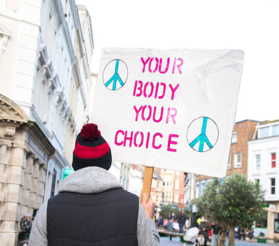 Your body your choice - signboard or placard poster peacefully in the street boy from behind