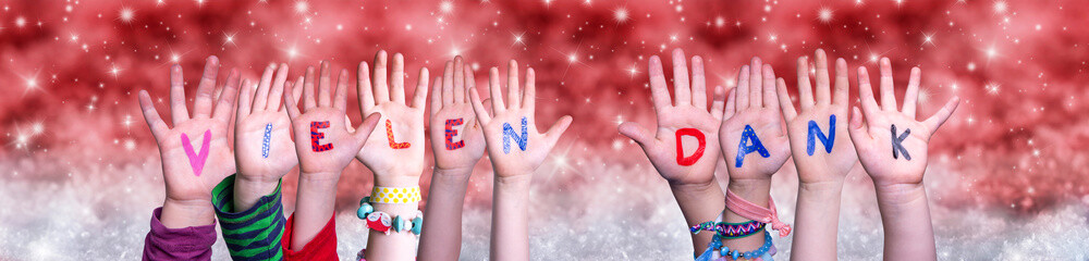 Children Hands Building Colorful German Word Vielen Dank Means Thank You. Red Snowy Christmas Winter Background With Snowflakes And Sparkling Lights