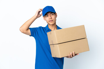 Delivery Chinese man isolated on white background having doubts while scratching head