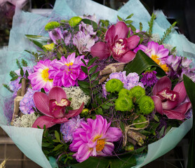 bouquet of bright pink flowers, orchids, prepackaged, in a flower shop. A bouquet for a holiday, celebration. Flower trade, private business, losses, loss of customers