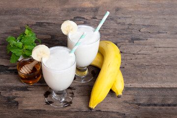 Banana fresh cocktail vanilla smoothies  fruit juice beverage healthy the taste yummy in glass drink episode good morning on wooden background from the top view.