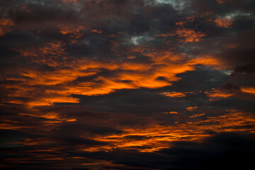 Fire red clouds shine in the air in the evening sun.