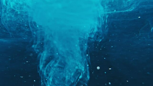 Paint fall into water which is twist. Spin acrylic ink drip into liquid. Visual effect bullet time, frozen moment, flow motion. Cloud fraction of color is spray drop. Slow motion cosmic video magic.