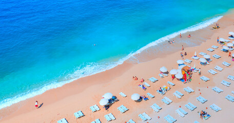 Holidaymakers sunbathing at Kaputas beach - Clear water sea and orange sand beach - Colorful Hot Summer Landscape of Kaputas Beach - Antalya Turkey