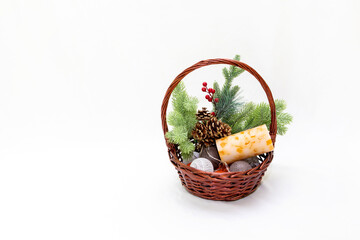 Christmas basket with branches of spruce berries a garland of candles on a white background with space for writing or text