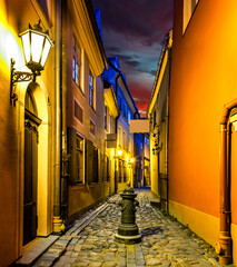 Narrow medieval street at night, old district in European town - obrazy, fototapety, plakaty