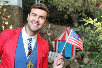 Businessman wearing dollar sign necklace holding US flag
