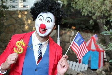 Spooky clown holding flag and dollar sign 