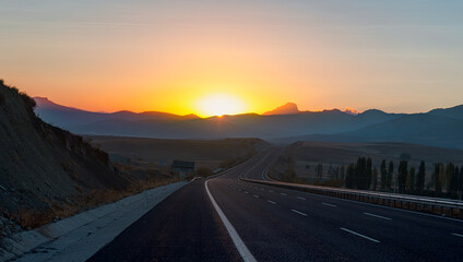 Curve asphalt highway road at amazing sunset