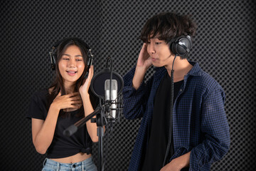 Couple singer singing in front of microphone in music studio