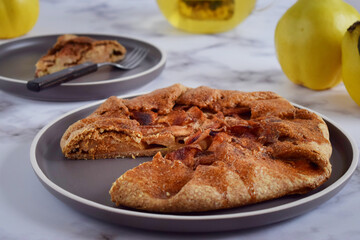 Quince galette with fresh quince. Traditional rustic fruit homemade pie, top view.