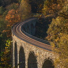 round stone train bridge in autumn colored forrest 