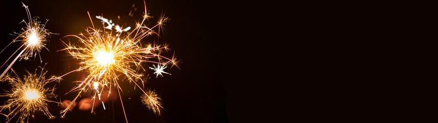 Silvester / New year background - People hold sparkling sparkler in her hand at dark night