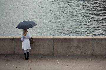Lonely girl with an umbrella. Sad autumn day.