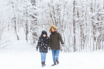 Fototapeta na wymiar Young couple walking in a snowy park. Winter season.