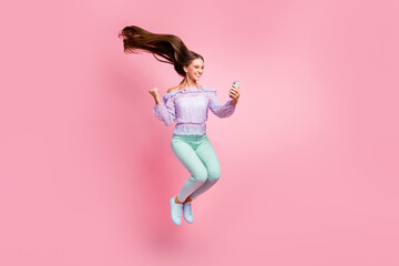 Full length photo of lucky teenager lady dressed casual clothes holding looking modern device...