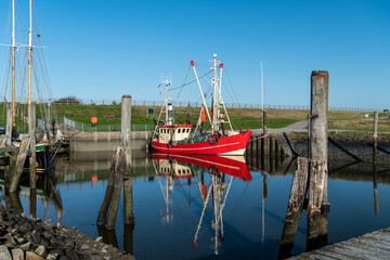 Rotes Boot mit Spiegelung im S&uuml;derhafen von Nordstrand bei Husum