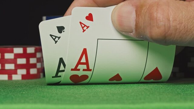 Pocket aces in a deck of playing cards with poker chips