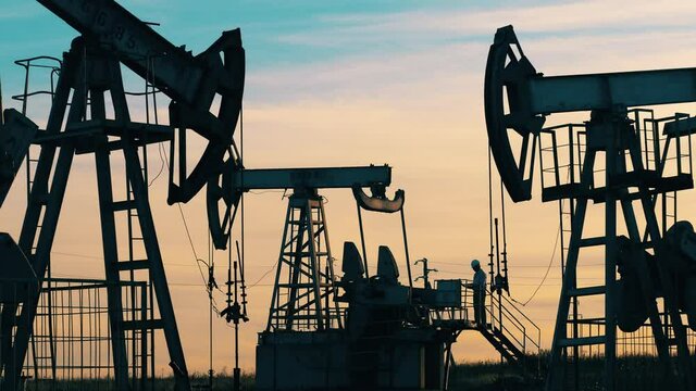 Crude oil, gas, petroleum prices concept. Engineer is observing an oil development site