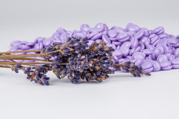 Violet wax drops and lavender for waxing depilation isolated on the white