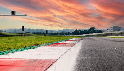 Sunrise sky over asphalt straight track motorsport circuit scenic background curb surface level