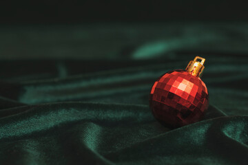 New Year card: Christmas ball on a green velvet background. Background for inscriptions and text.