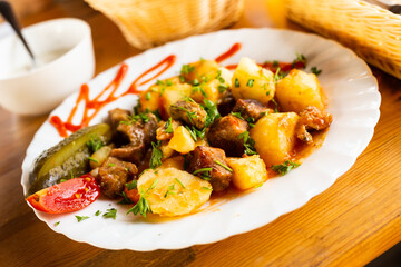 dish of baked potatoes with beef stew with herbs