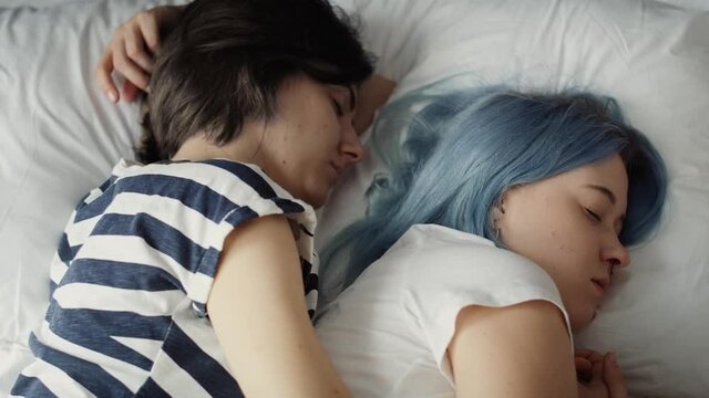 Top view video of lesbian couple sleeping on bed. Shot with RED helium camera in 8K.