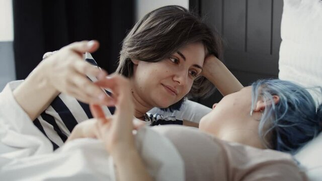 Video of romantic lesbian couple holding hands in the bed. Shot with RED helium camera in 8K.
