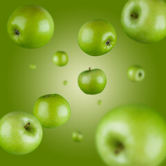 Many green apples free falling on gradient green background. Selective focus - shallow depth of field.