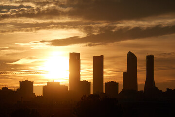 The sunset behind the Cuatro Torres de Madrid seen from the Valdebebas forest park. Spain