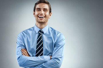 Handsome cheerful american executive business man on grey background. Business concept
