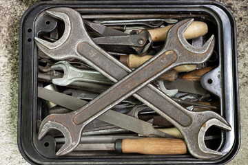 A box with a set of old rusty locksmith tools.