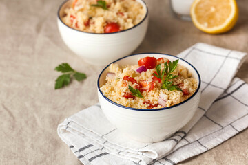 Tabouleh is an Arabic vegetarian salad made with couscous, tomatoes, parsley, onion and lemon juice. Copy space.