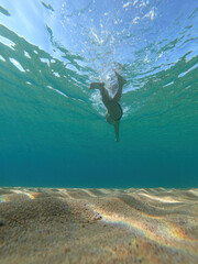 Sporty man swimming in a clear sea water in Spanish Costa Brava in summer