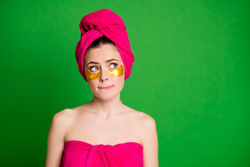 Lady look up unsure use under eyes patches have difficult choice wear towels body head isolated green color background