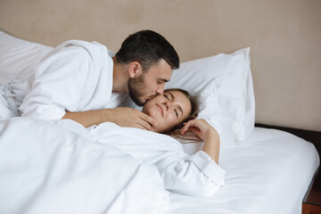 Obraz na płótnie Canvas Kissing in white bed