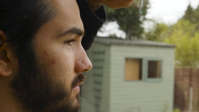 Male looking out of a window longingly in quarantine close up