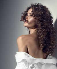 Beautiful young woman with curly hair posing, beauty model portrait, closeup. Beautiful sexy model...