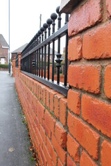 UK domestic brick wall with railings, shallow DOF