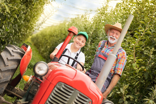 Happy grandfather and grandson on tractor