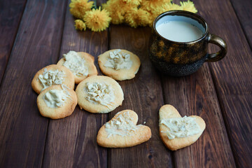 homemade cookies in nuts and a cup of milk on a wooden background. Valentine's Day. romantic atmosphere